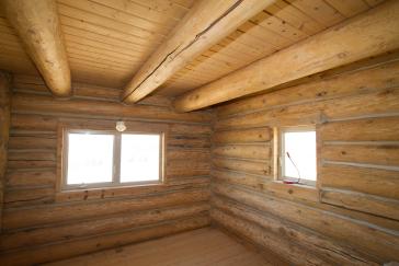 Interior of a timber frame wood cabin with modern windows.