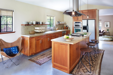Kitchen island with wooden cabinets and hood vent.