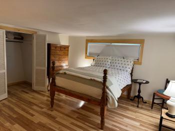 Bedroom with wood-trim window and new floors.