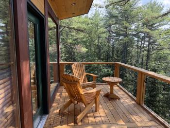Wood balcony looking out onto the maine woods.