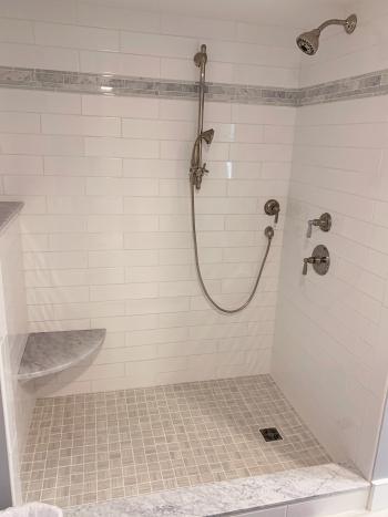 Walkin Shower with white tile and multiple shower heads.