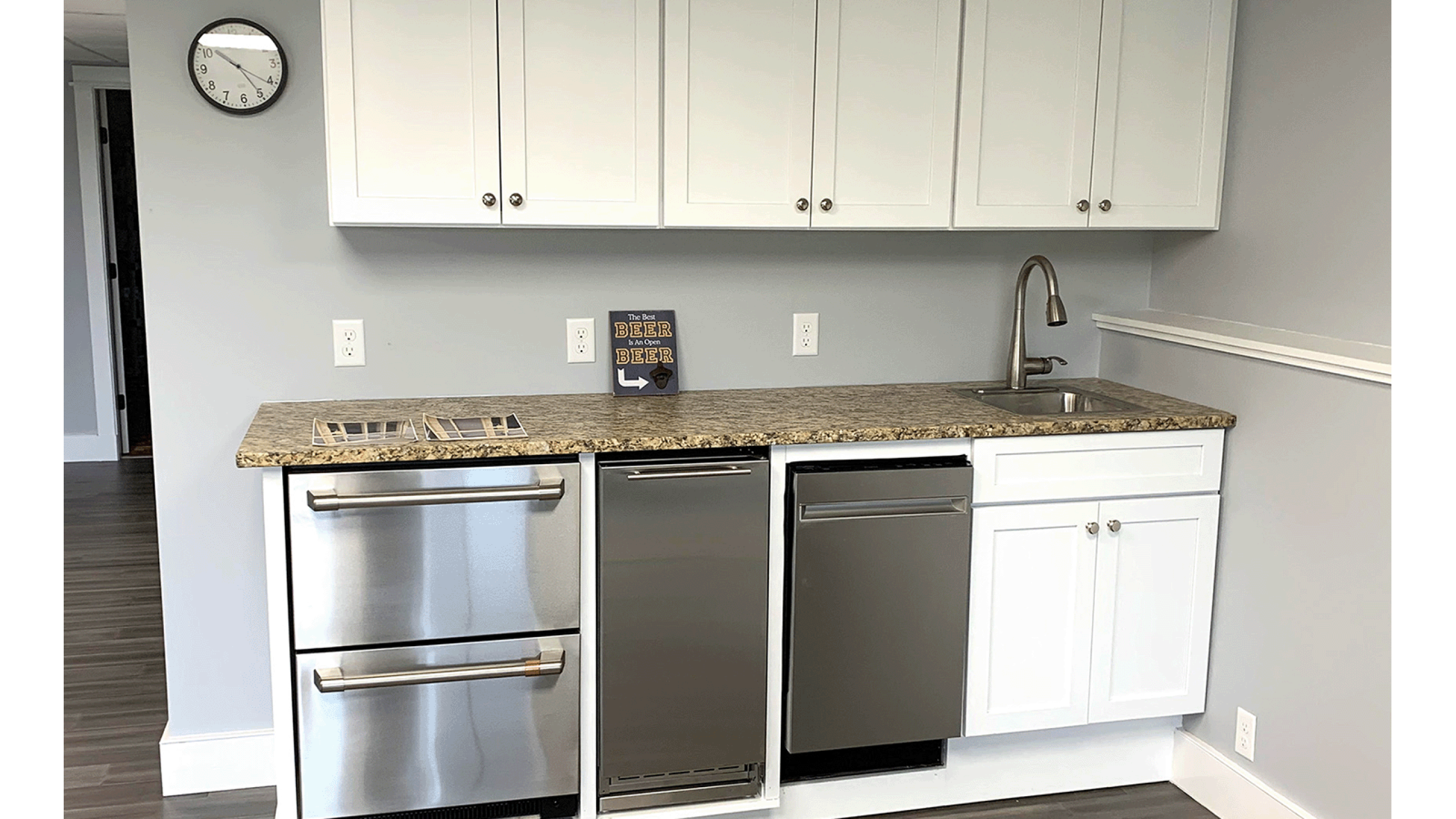 Kitchenette in basement with sink and appliances.