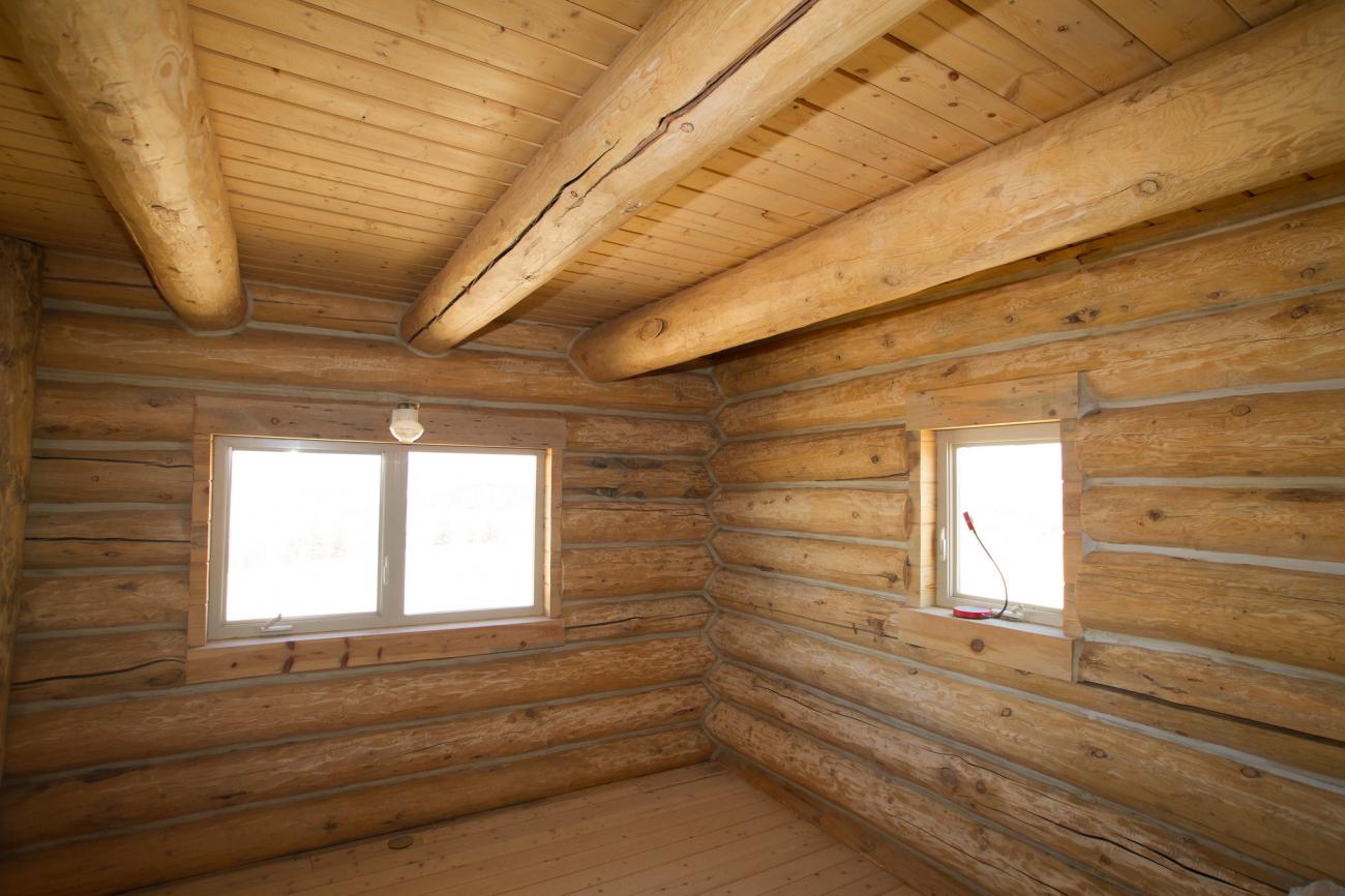 Interior of a timber frame wood cabin with modern windows.