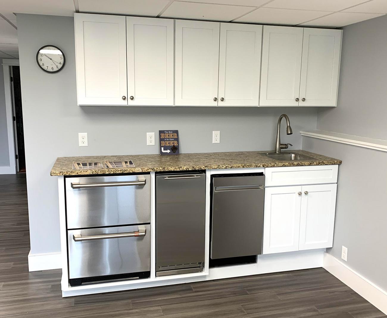 Basement bar with countertop with dishwasher, mini fridge, sink and cabinets. 