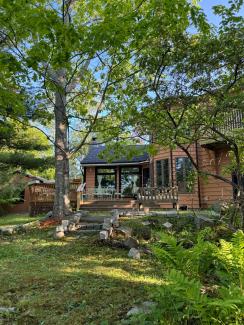 Window installation and back deck amongst trees and a green lawn