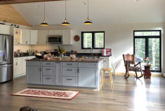 Kitchen island and remodel with pendant lighting solutions and appliances.