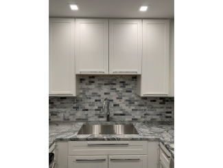 Kitchen with tile backsplash and stainless steel stink.