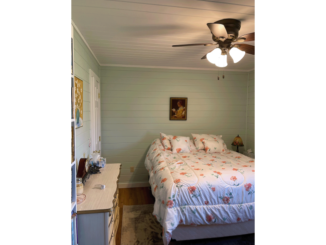 Bedroom with shiplap painted a light mint green.
