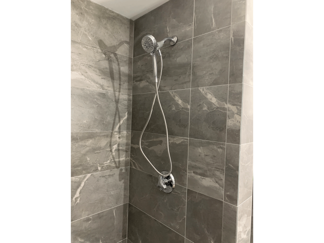 New gray marble walk in shower with detachable shower head.