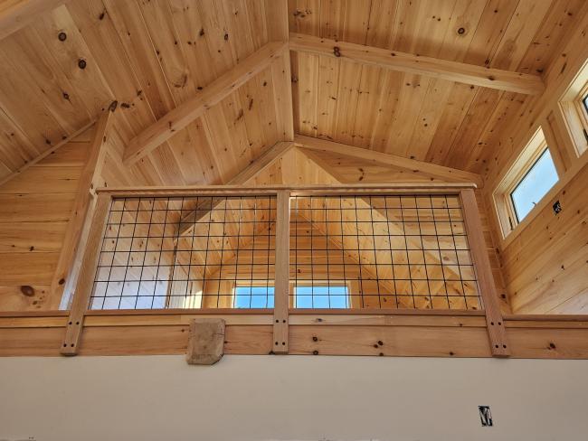 Exposed wood truss roof under construction.