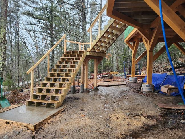 Custom carpentry in progress for a long, winding staircase.