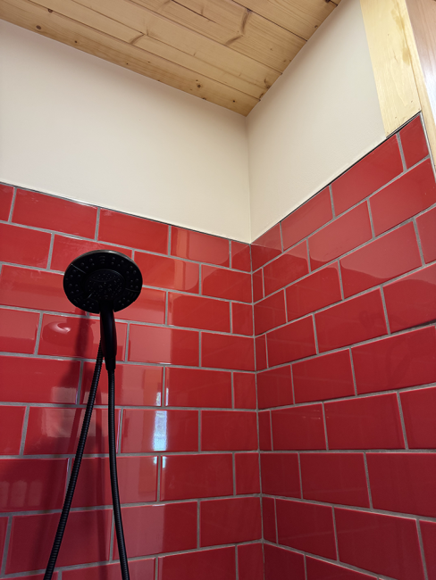 Ceiling and shower head of the read tiled.