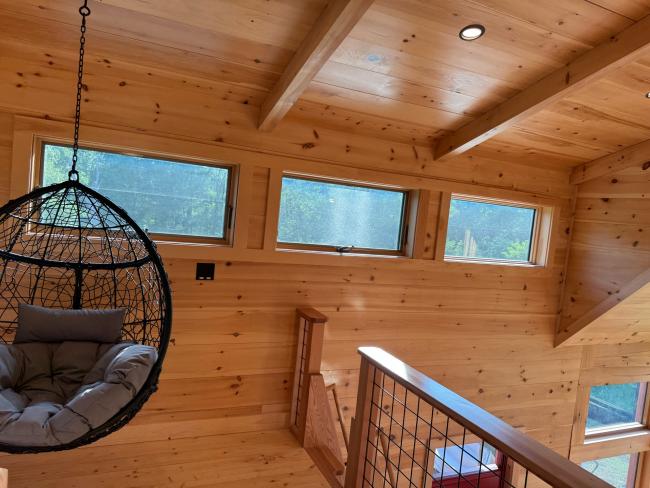 Loft room in a wood cabin with clerestory windows installed.