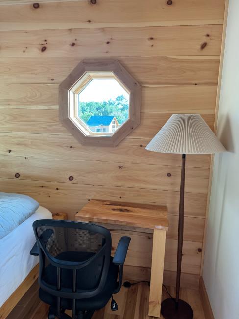 Octagonal window with wood clapboards.