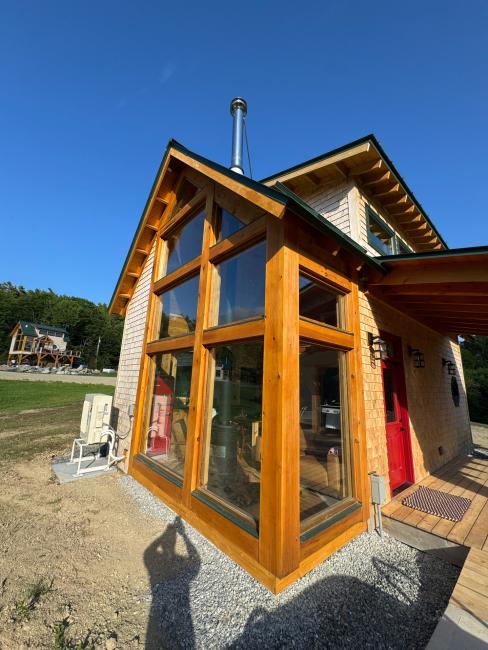 Exterior view of wood timber framing and large corner windows.