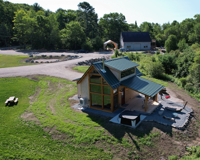 Aerial view of The Cherry cabin with ample natural window light, covered porch, and timber beams artfully exposed.