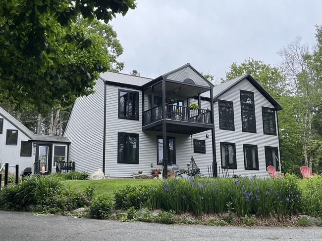 View from the driveway of connecting staircase (Image Left) and newly built home addition (Image Right). The original home stands in between.