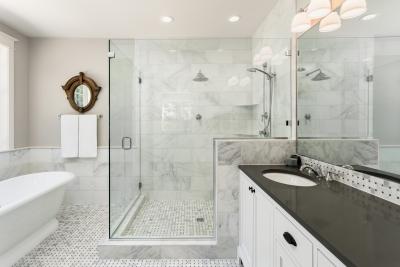 Large bathroom remodel with walkin glass shower with multiple showerheads, large tub, and ample countertop space.