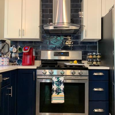 Kitchen remodel with retro fixtures, including hood and gas range with oven.